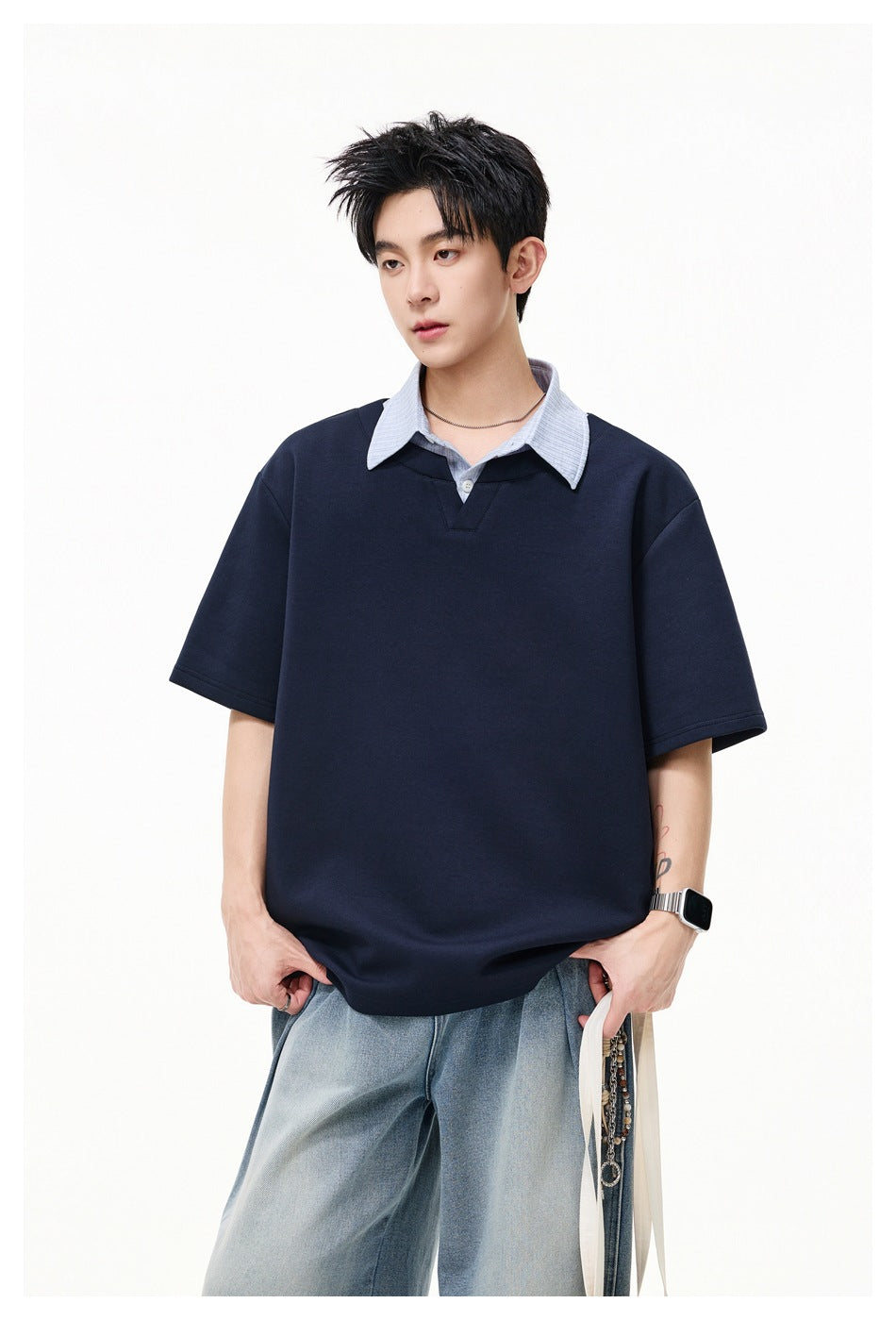 Close view of a model wearing a navy short-sleeve top with a pale striped collar and placket.