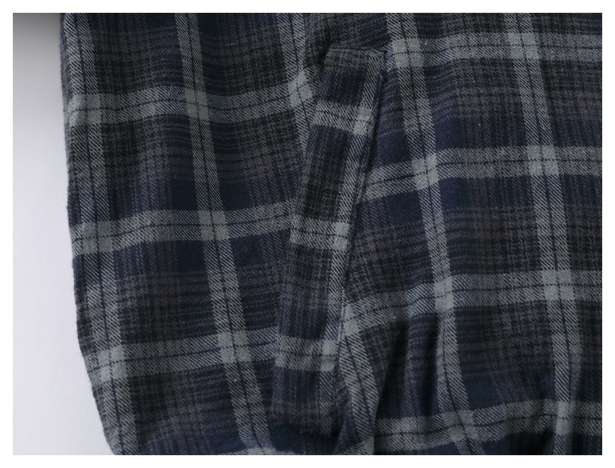 Close-up of dark navy and gray plaid fabric with a narrow folded fabric detail.