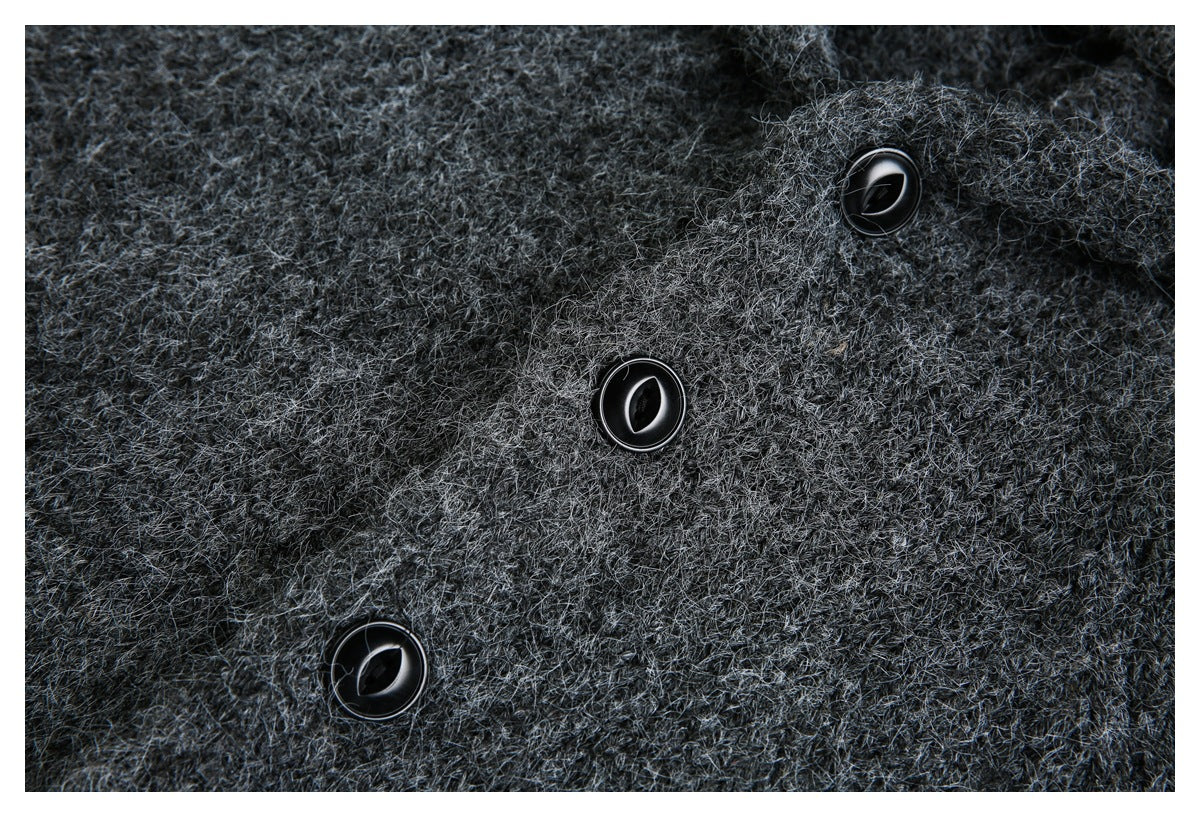 Close-up of three glossy black buttons on a charcoal gray fuzzy knit garment.