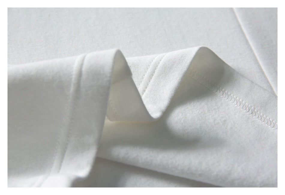 Close-up of a white garment's folded seam and overlock stitching.