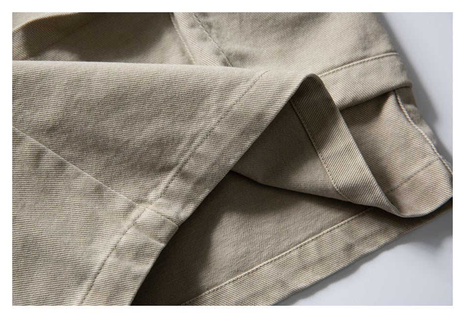 Close-up of the folded hem on beige shorts, showing the inner fabric and stitching.