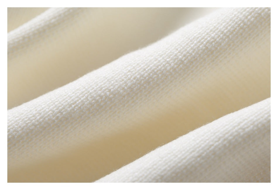 Macro view of the soft-looking knit texture of an ivory sweater.