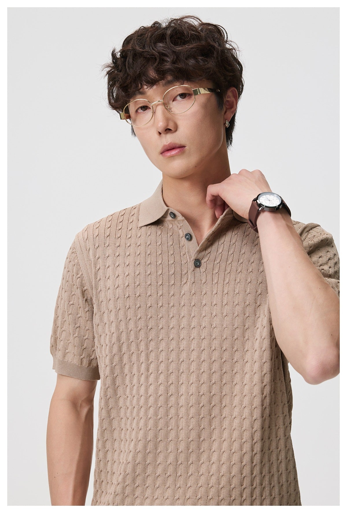 Close-up of a model wearing a taupe textured short-sleeve polo with a collar and three-button placket.