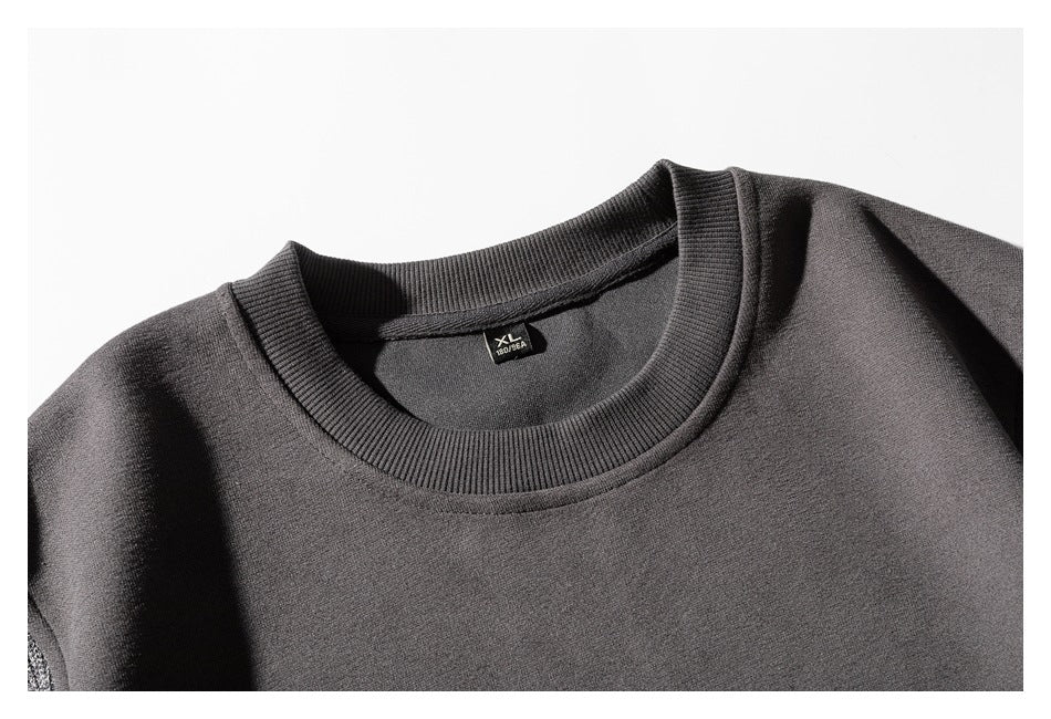 Close-up of a charcoal crewneck sweatshirt showing its ribbed neckline and small size label.