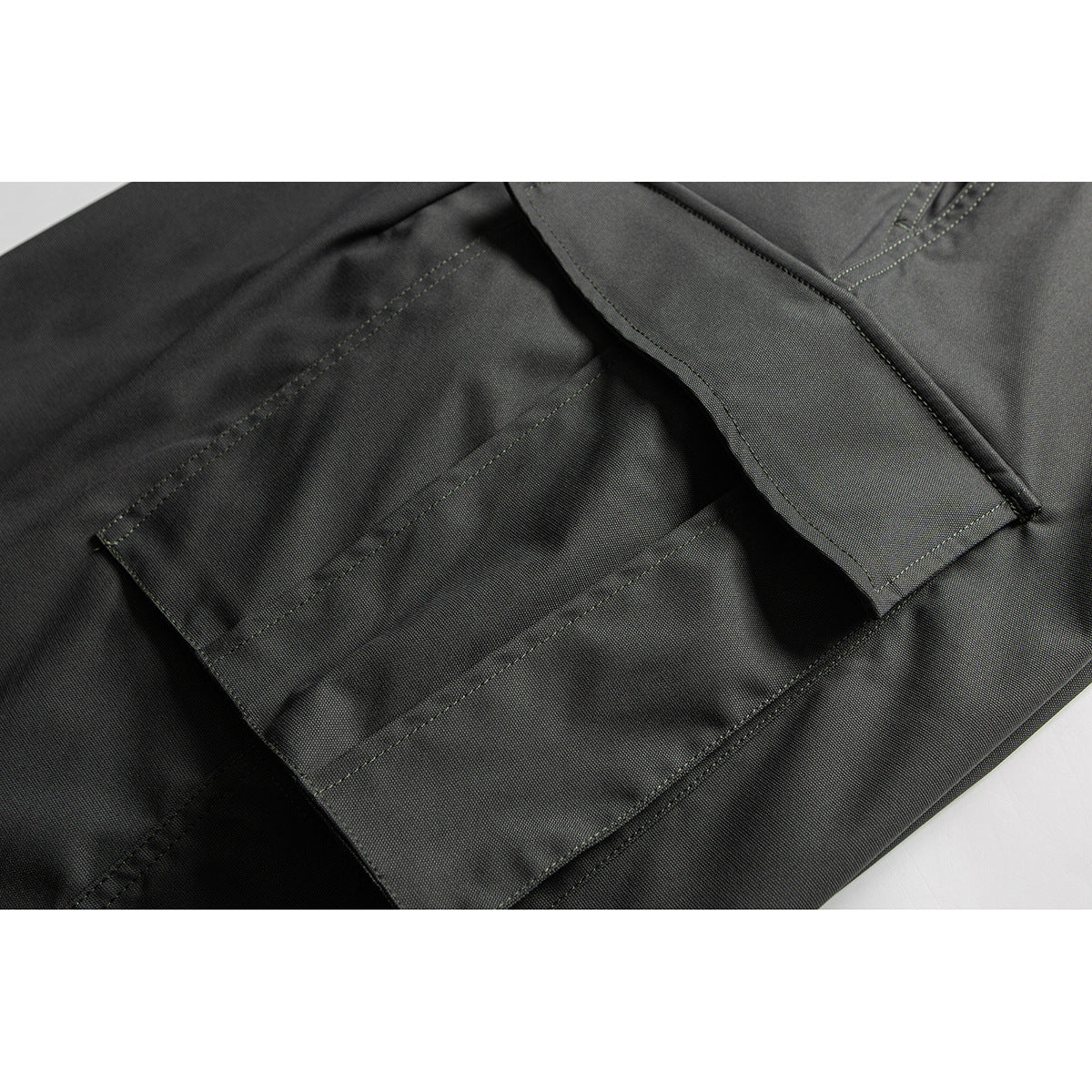 Close-up of a dark gray cargo pocket and stitched seams on the pants.