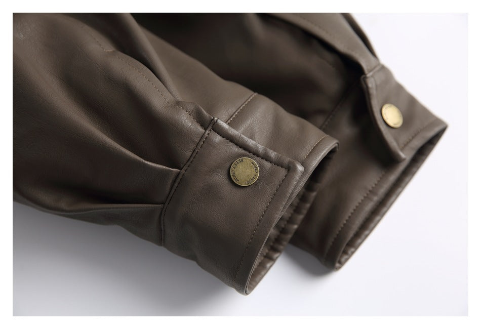 Close-up of a brown jacket sleeve cuff with gold-tone snap buttons and visible stitching.