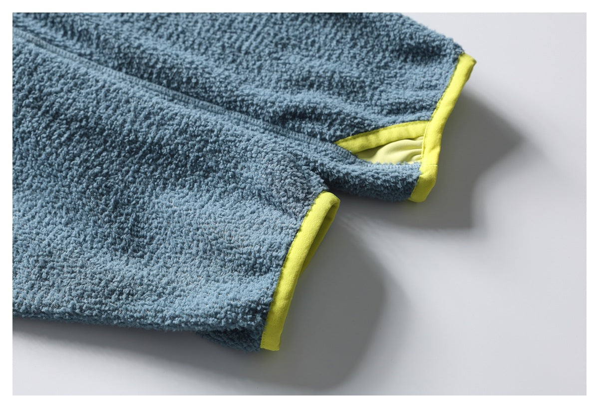 Close-up of blue textured fleece sleeve cuffs finished with bright yellow-green binding.