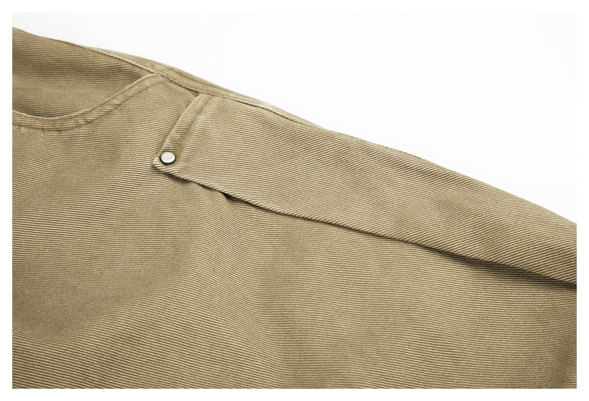 Close-up of a khaki trouser flap pocket with a silver snap and visible fabric stitching.