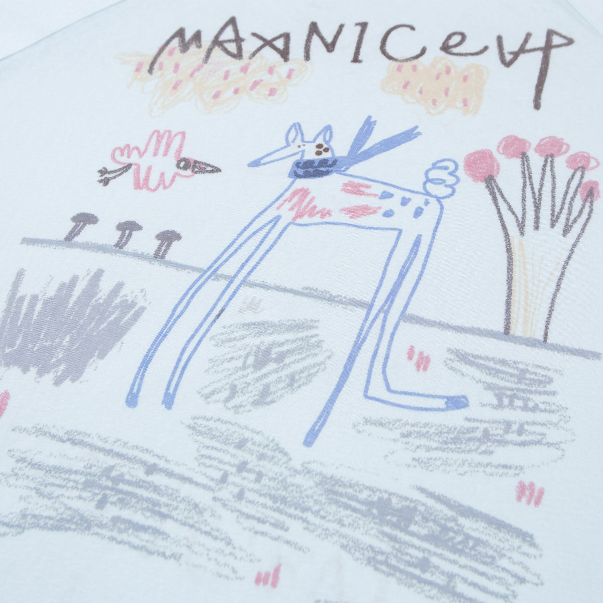 Close-up of a pale blue shirt showing a colorful hand-drawn animal and landscape print.
