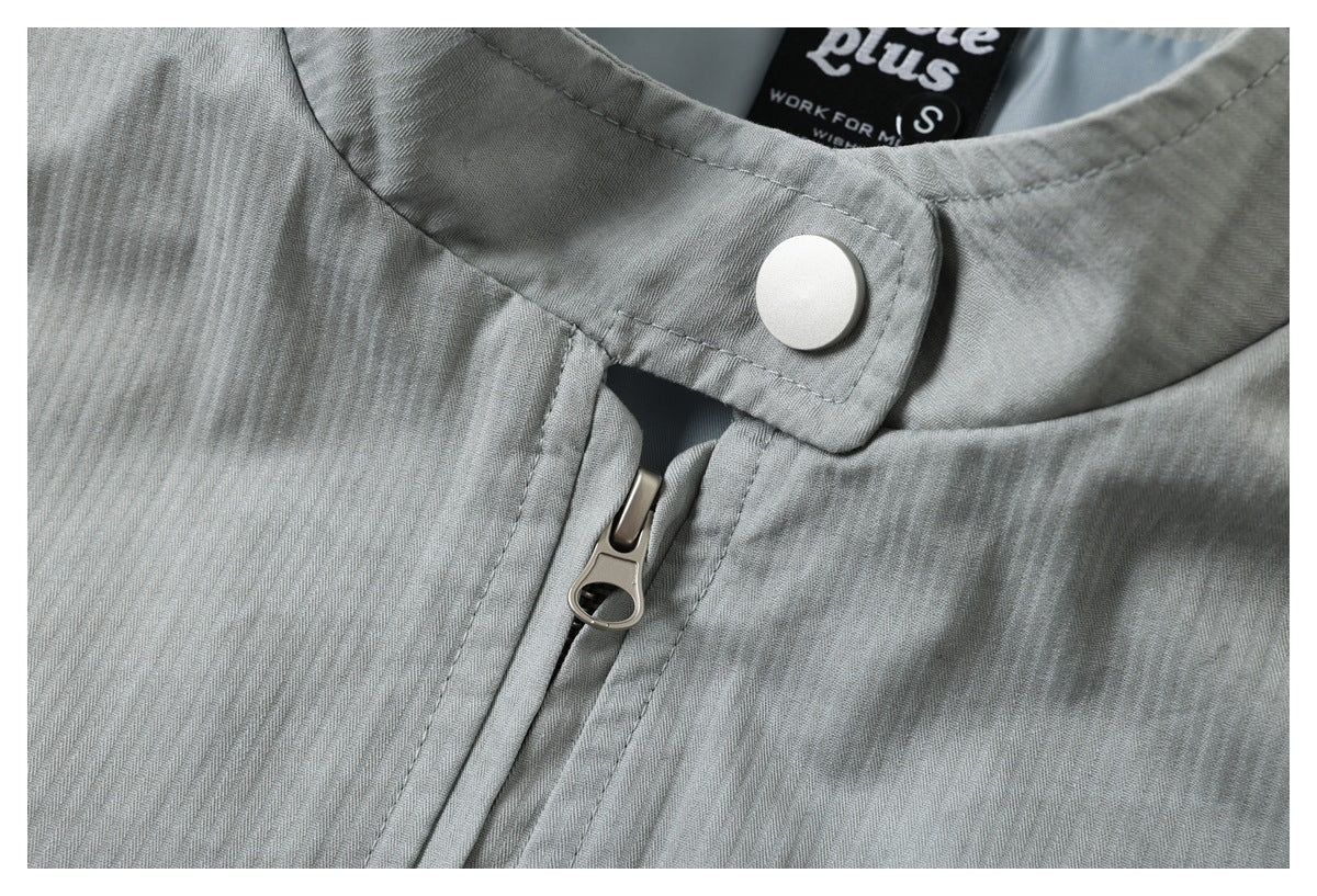 Close-up of the light gray jacket's collar snap and metal front zipper pull.