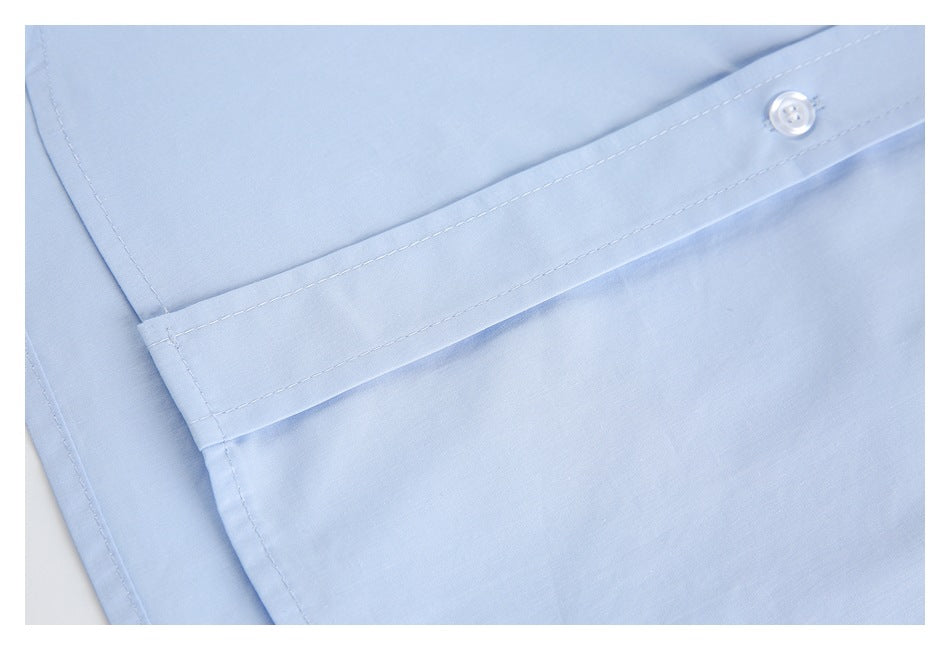 Close-up of a light blue shirt's buttoned placket and stitched seams.