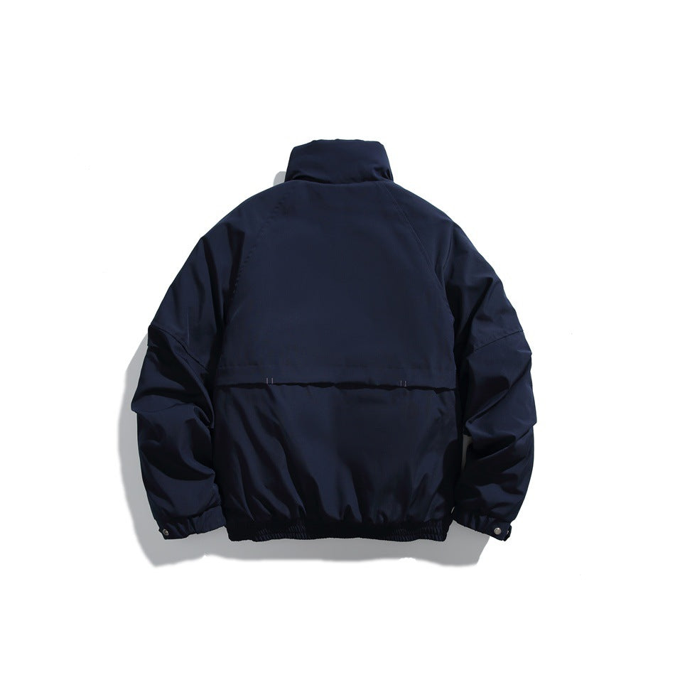 Back view of a dark navy jacket with a high collar, gathered hem and a horizontal back seam.