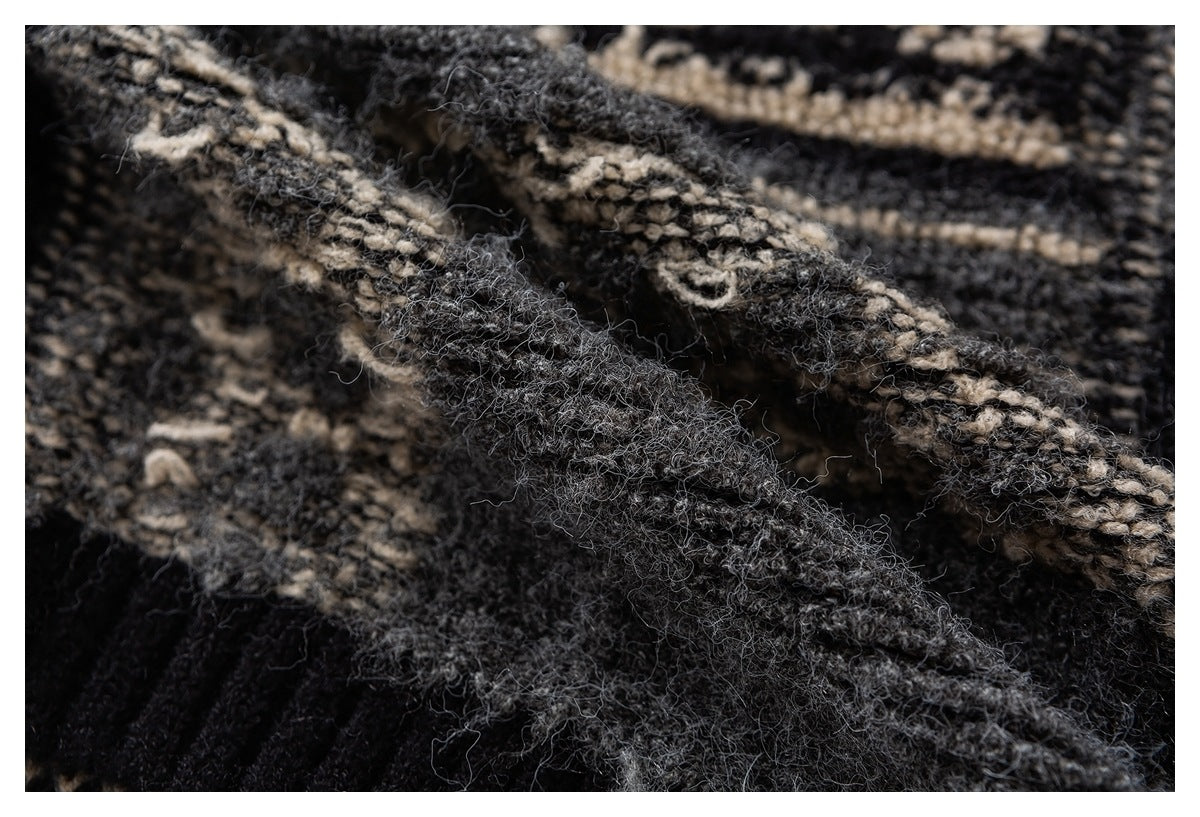 Close-up of textured charcoal knit and cream geometric pattern, showing a folded seam and ribbed section.