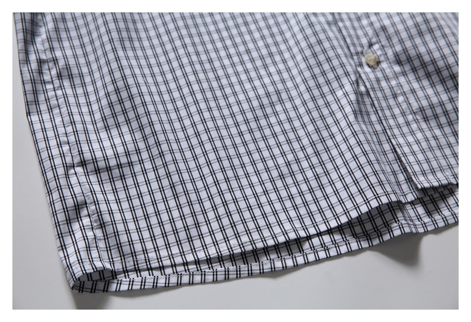 Close-up of the plaid shirt's lower hem and straight stitching.