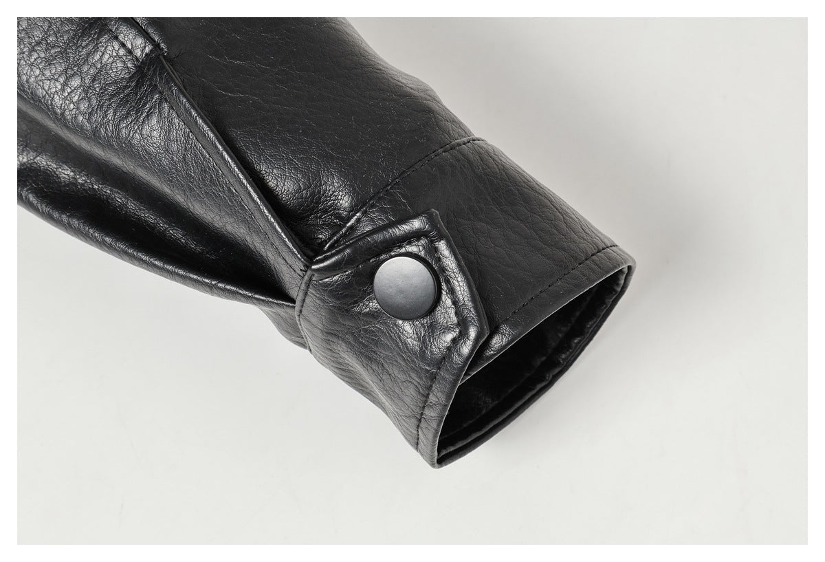 Close-up of a black jacket sleeve cuff with a round snap button and visible stitching.