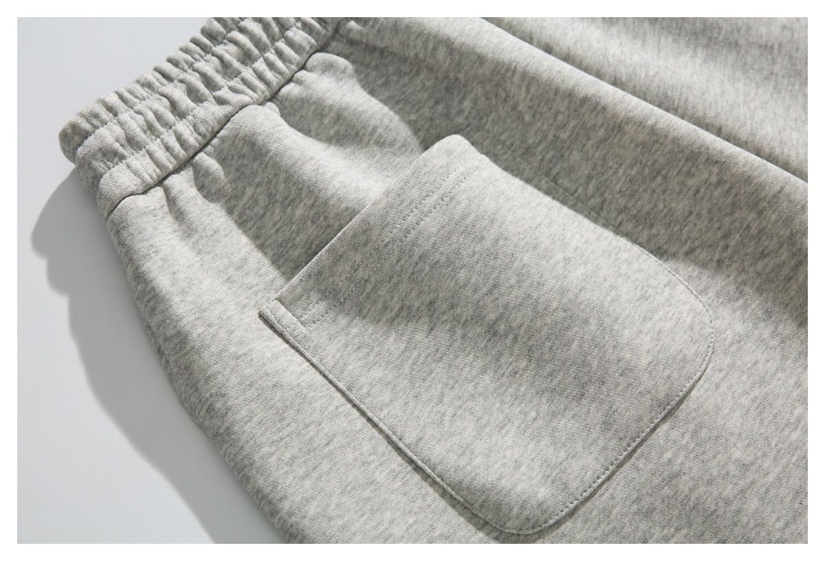 Angled close-up of gray heather shorts highlighting the elastic waistband and front patch pocket.