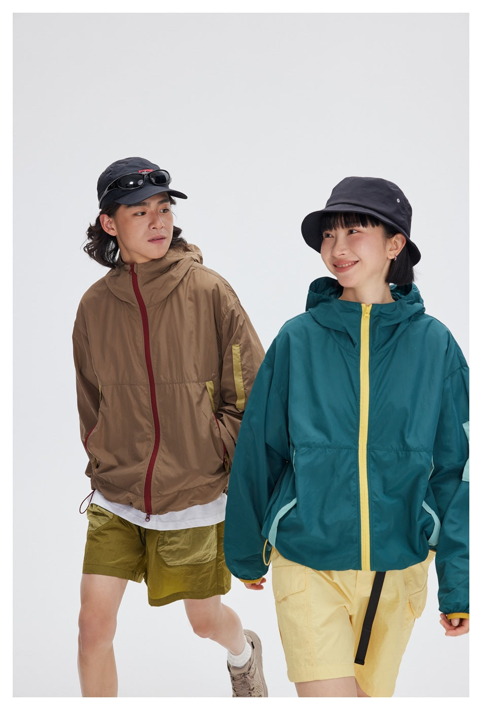 Closer view of two models in taupe and teal hooded jackets with contrasting trim.