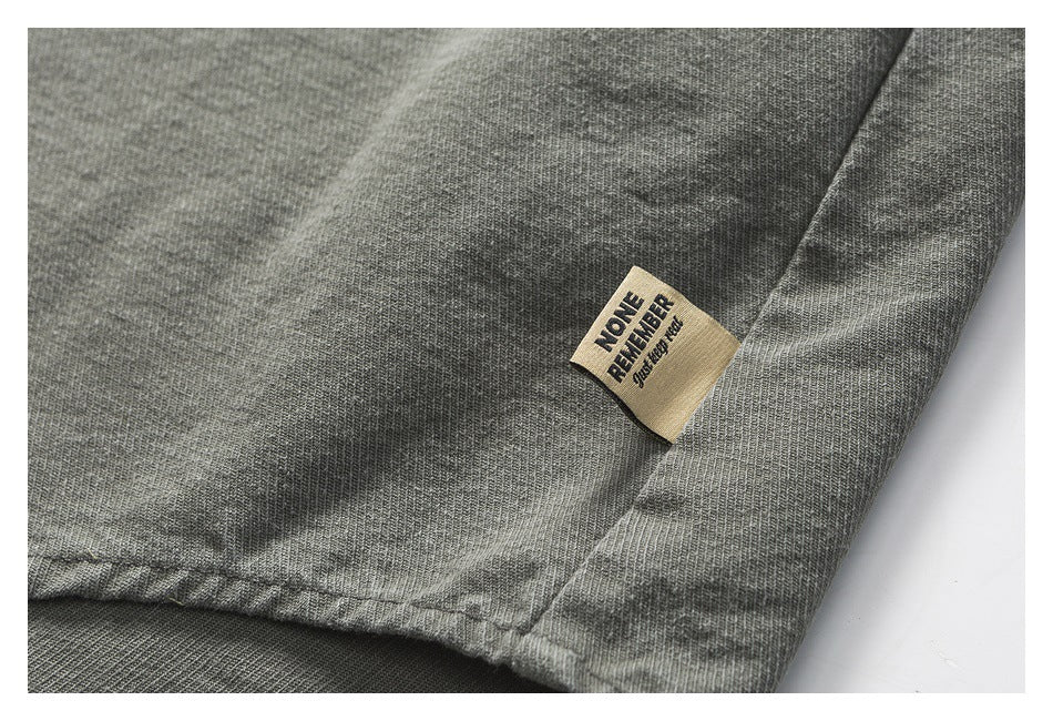 Close-up of a gray garment hem with a small beige fabric label bearing English text.