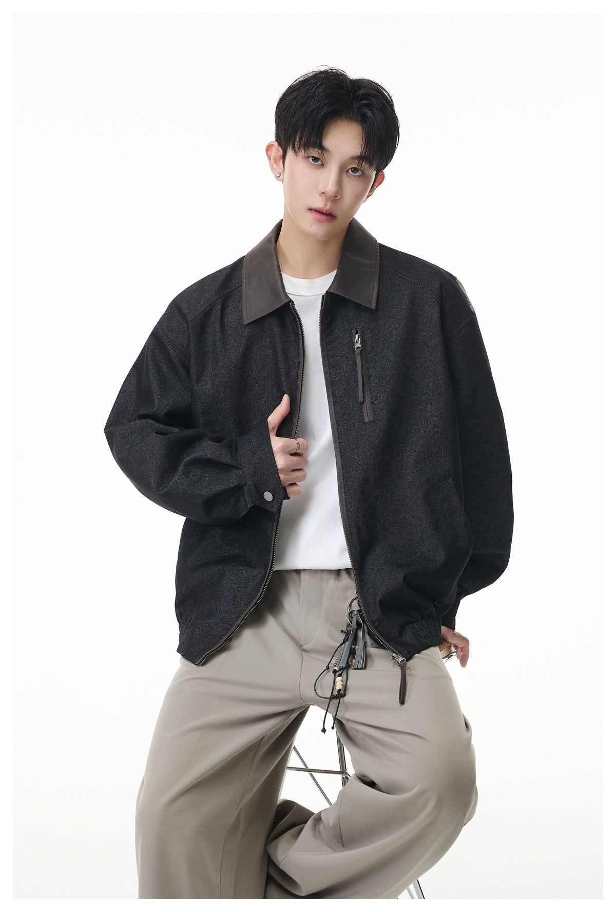 Model wearing an open charcoal jacket with a contrasting dark collar, chest zipper pocket and roomy sleeves.