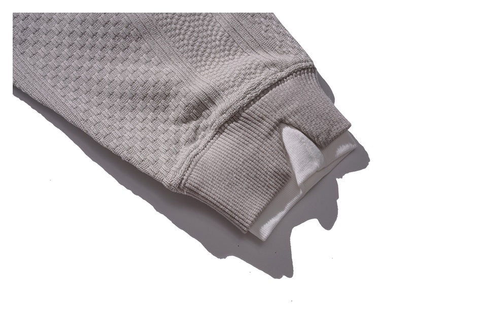Close-up of a ribbed gray sweatshirt cuff and the textured sleeve fabric.