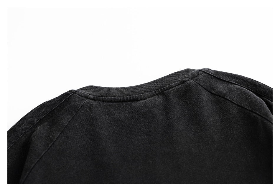 Close-up of a black crew neckline and raglan shoulder seams.