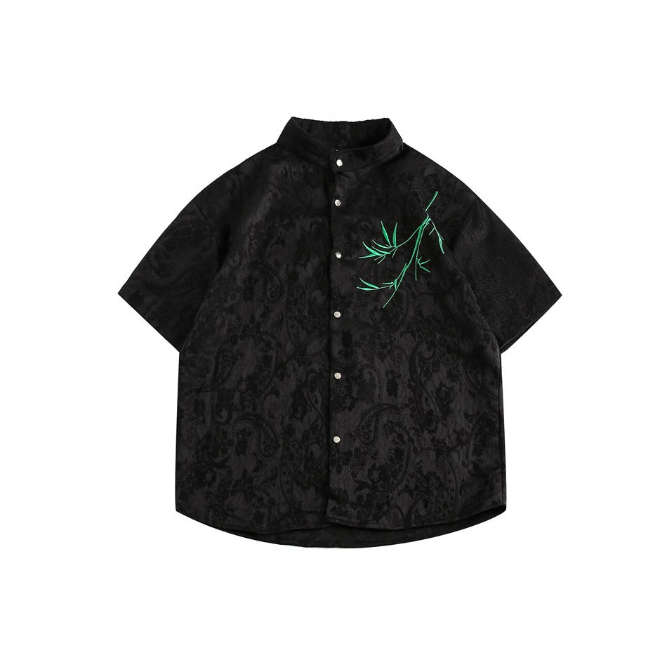 Black short-sleeve stand-collar shirt with tonal jacquard pattern, snap buttons and green embroidered bamboo on the chest