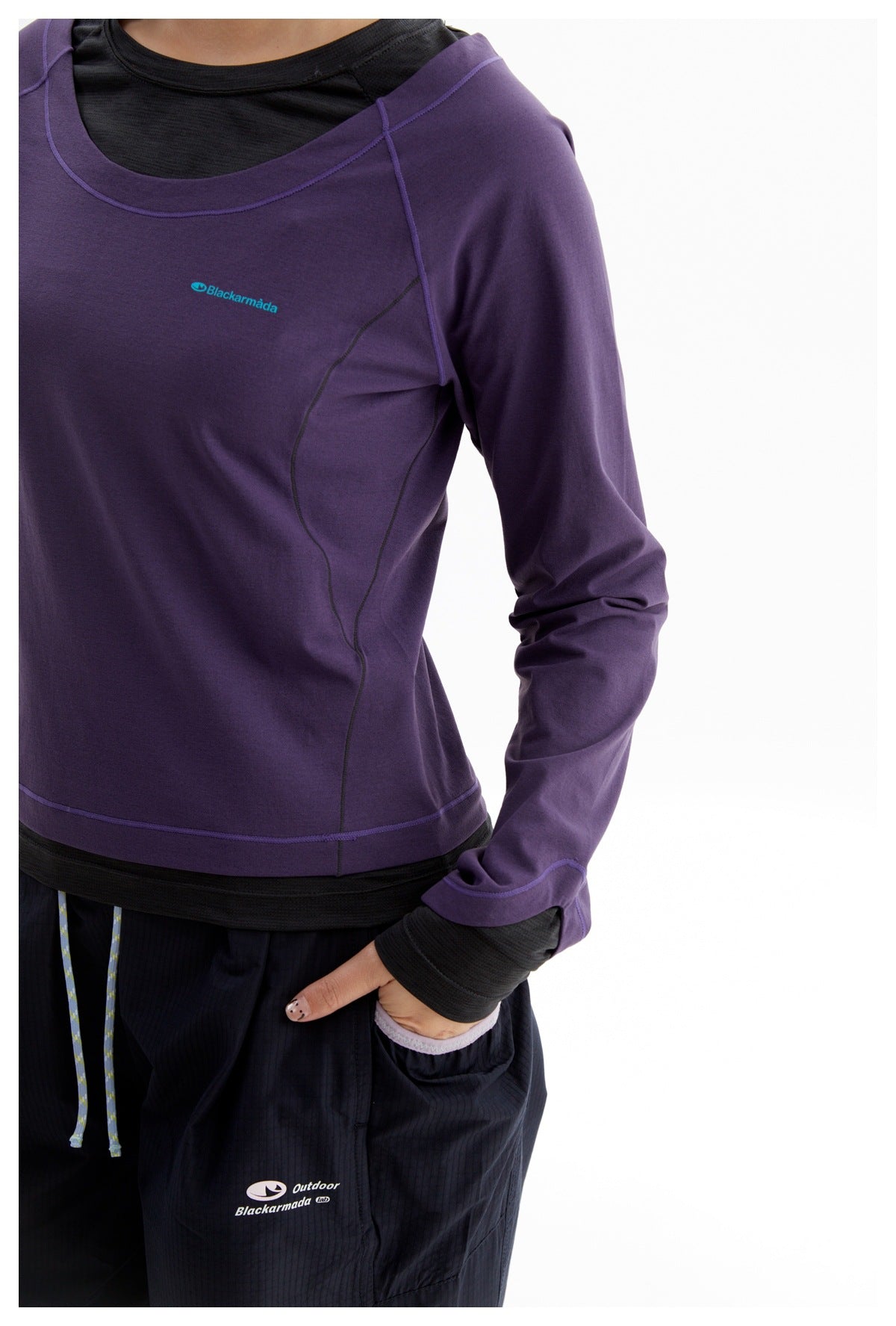 Cropped front view of a person wearing a purple long-sleeve top with contrast seams and a small teal chest logo.