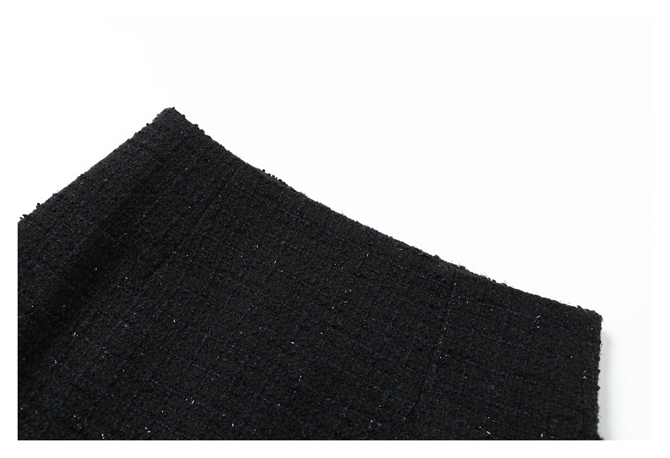 Close-up of black textured fabric with subtle flecks against a white background.