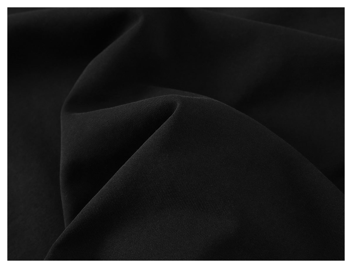 Extreme close-up of smooth black sweatshirt fabric gathered into soft folds.