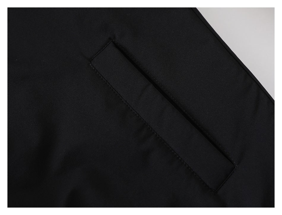Close-up of a slanted welt pocket on the black jacket.