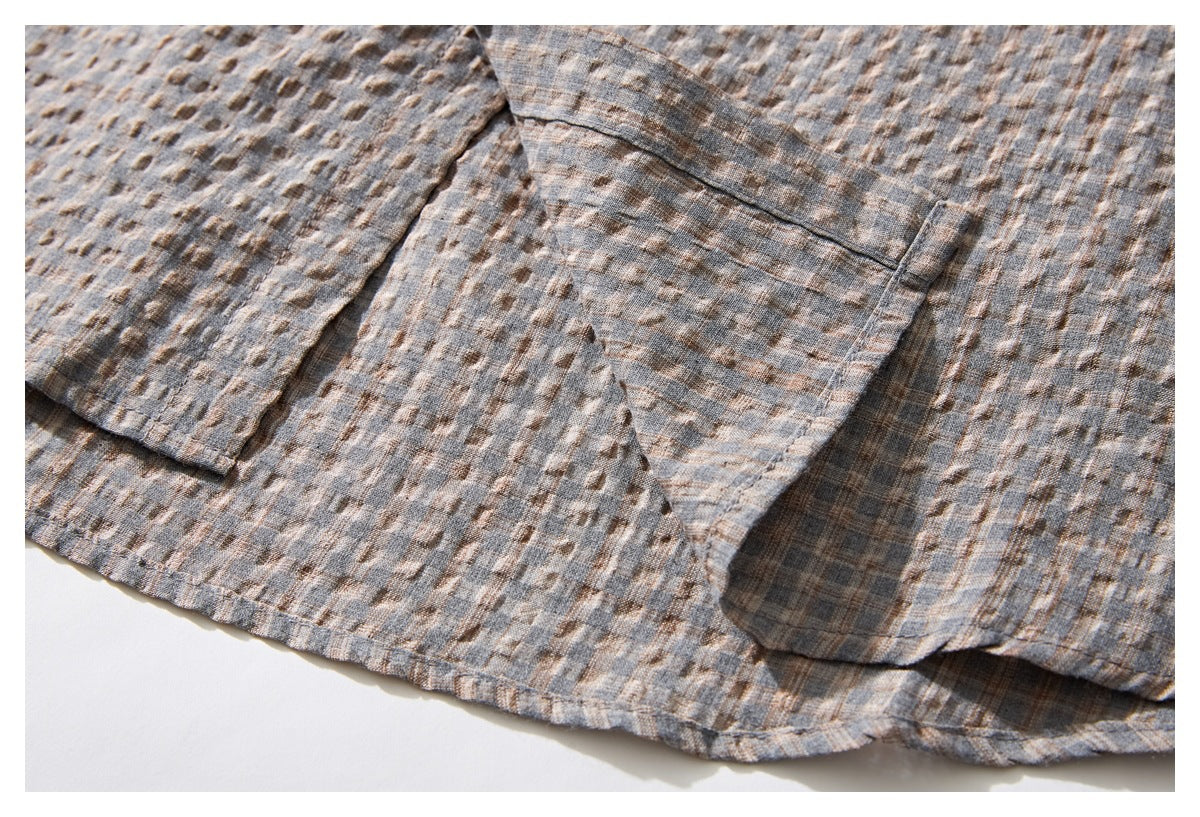 Close-up of the gray-brown patterned shirt hem and overlapping pocket details.