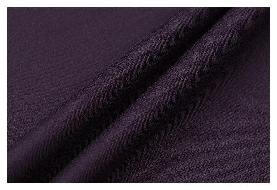 Close-up of dark plum fabric draped to show its fine surface texture.
