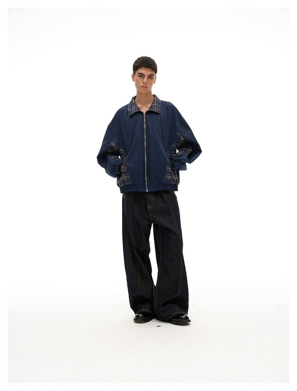 Full-length front view of a model wearing a navy jacket with plaid collar and side panels, and wide black jeans.