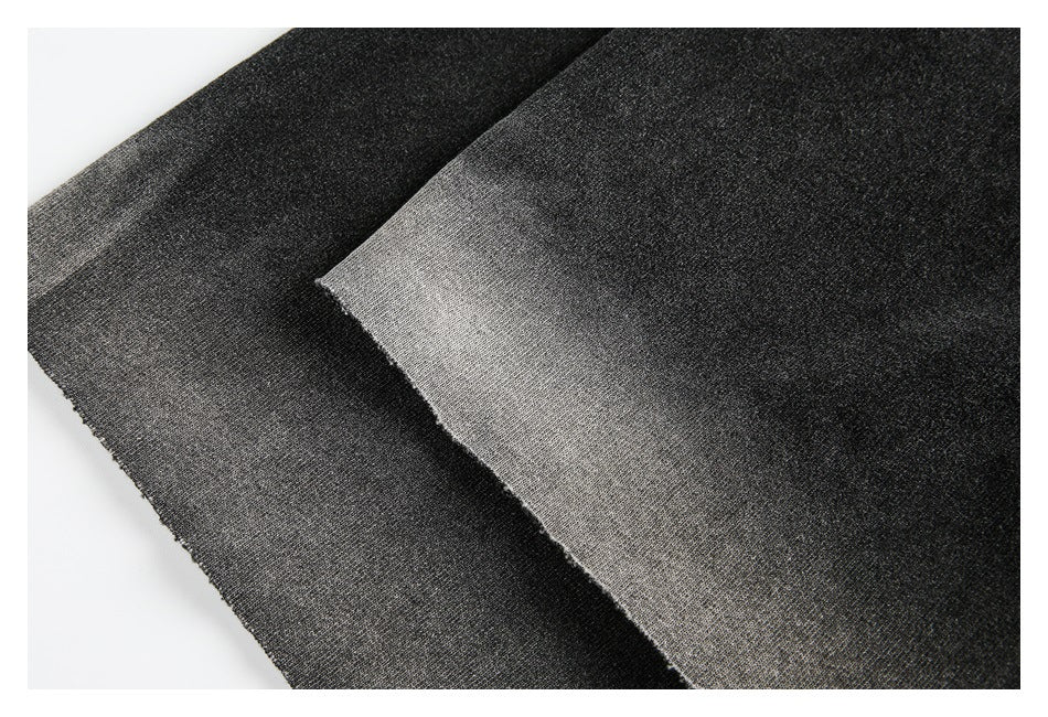 Close-up of overlapping black and charcoal-gray fabric panels with visible knit texture.