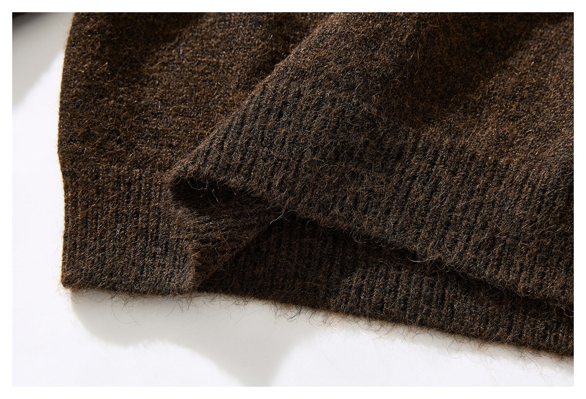 Close-up of a dark brown knit sweater with a folded ribbed edge.