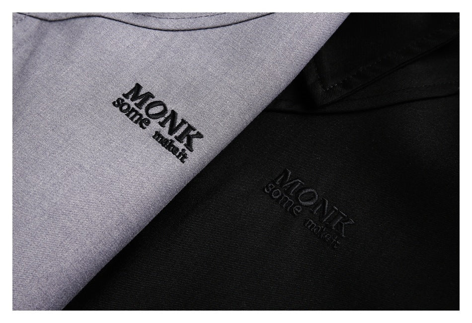 Close-up of gray and black garments, each with black embroidered lettering.