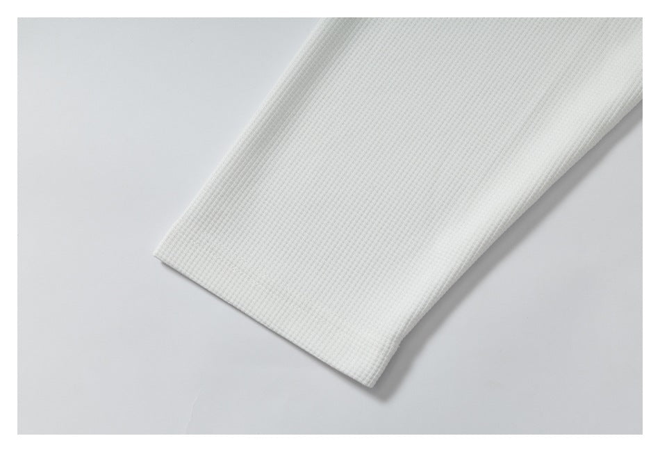Close-up of plain white textured fabric folded to show its edge.