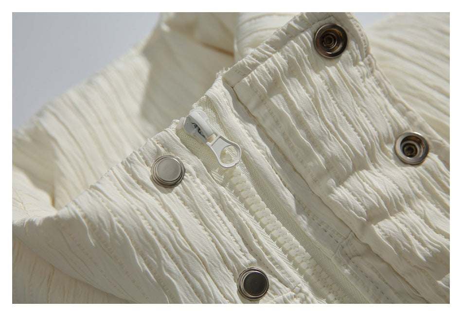 Close-up of an ivory jacket zipper and several metal snap fasteners.