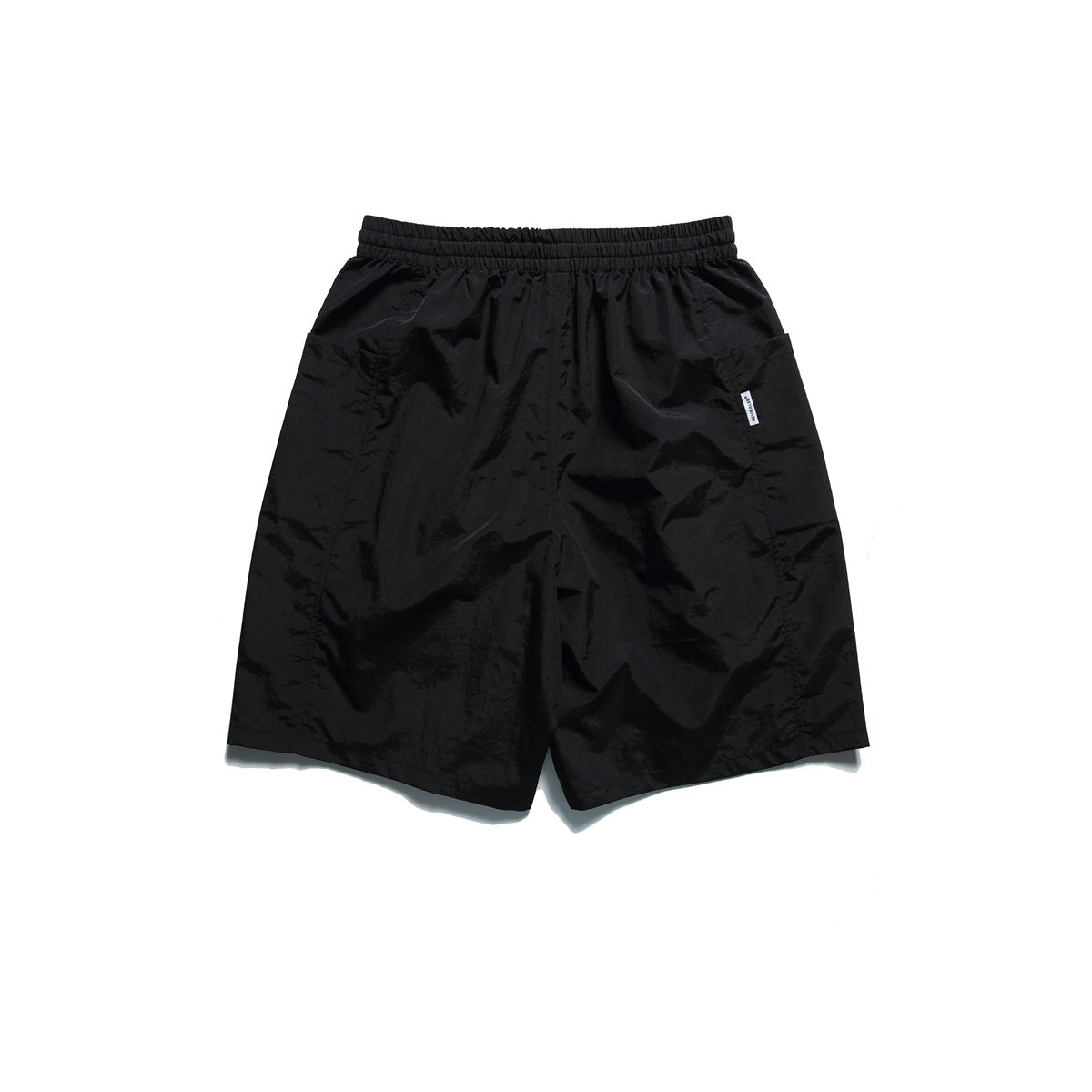 Black shorts laid flat, with an elastic waistband, side pockets and a small white tag.