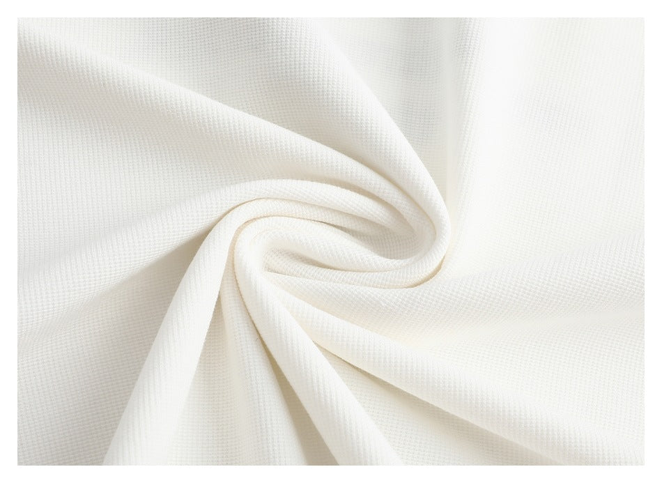 Close-up of white fabric gathered into a swirl, showing its fine textured surface.