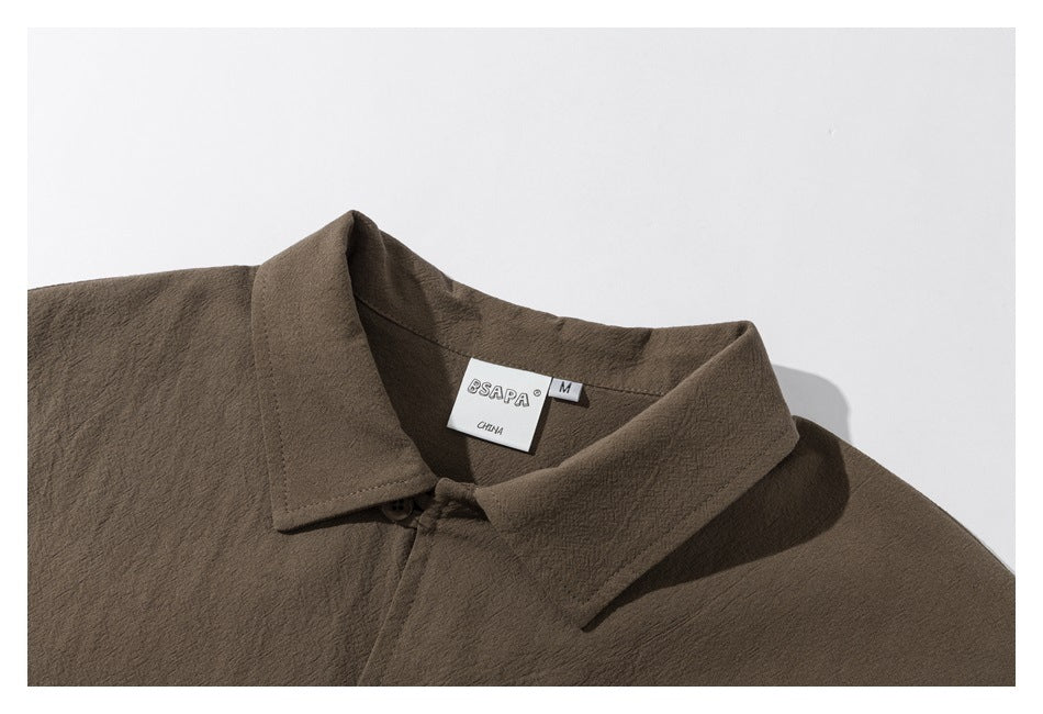 Close-up of a brown shirt collar and inner neck label with a size M tag.