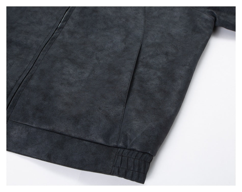 Close-up of the dark jacket's lower front panel, seam, and elasticized hem.