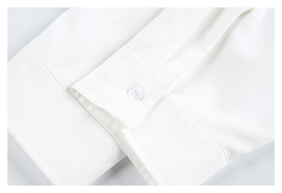 Close-up of a white cuff with a single white button and visible stitching.
