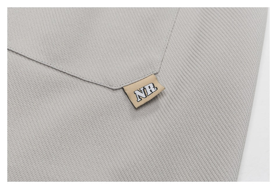 Close-up of a light gray textured garment with a small tan fabric tag marked NFL.