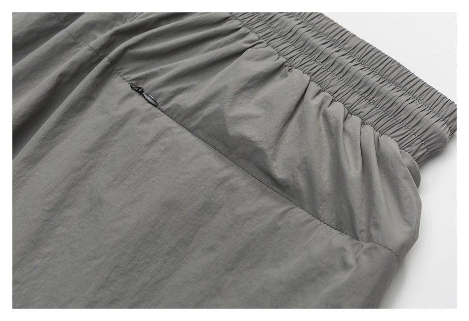 Close-up of gray shorts with an elastic waistband and a small zip pocket.