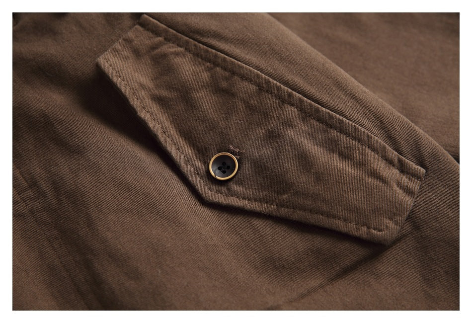 Close-up of a brown flap pocket with a dark button and tan rim.