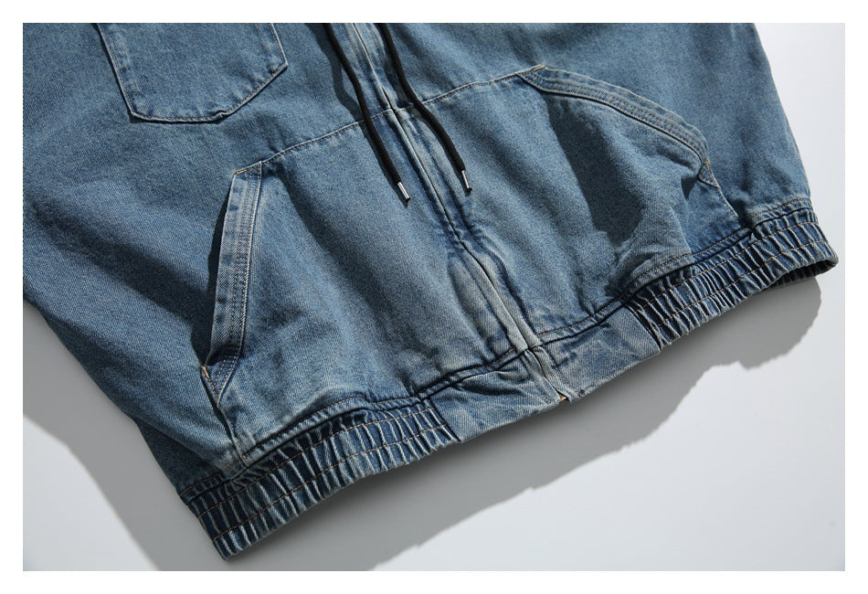 Partial front view of a blue denim hoodie with drawstrings, a kangaroo pocket, and an elasticized hem.