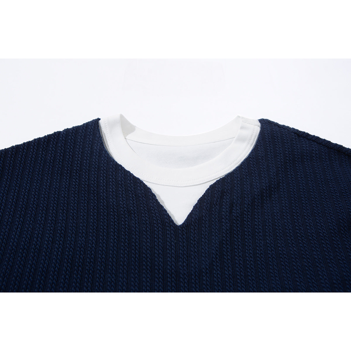 Close-up of a navy ribbed top's white crew neckline and contrasting V-shaped inset.