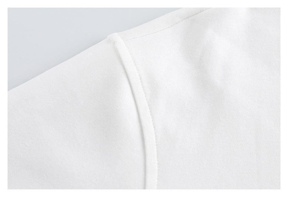 Close-up of white garment fabric with a curved stitched seam.