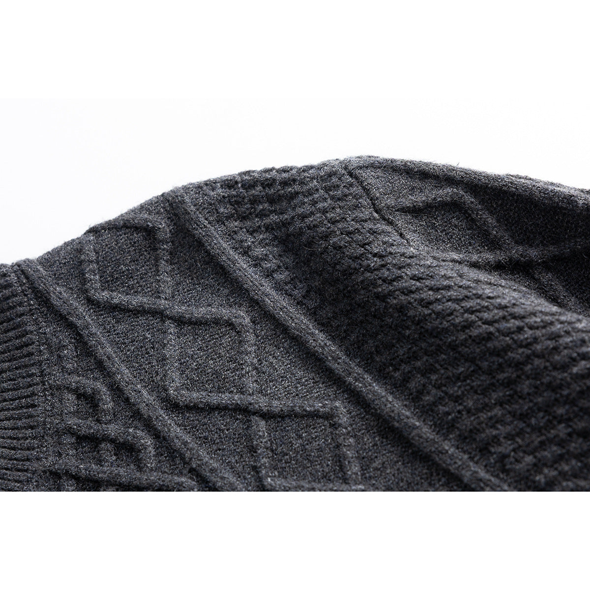Close-up of the charcoal cardigan's raised cable-knit and textured stitch patterns.